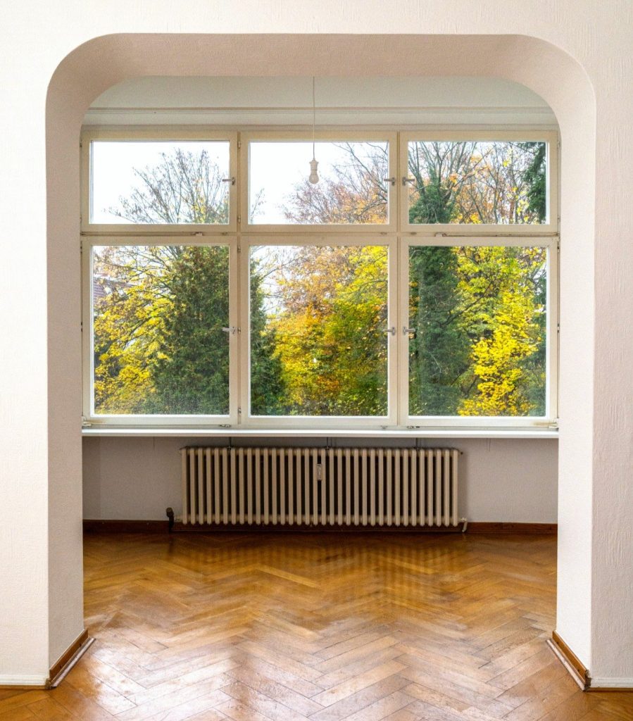 Der Wintergarten im Erdgeschoss mit großem Sprossenfenster und Blick über den Garten
