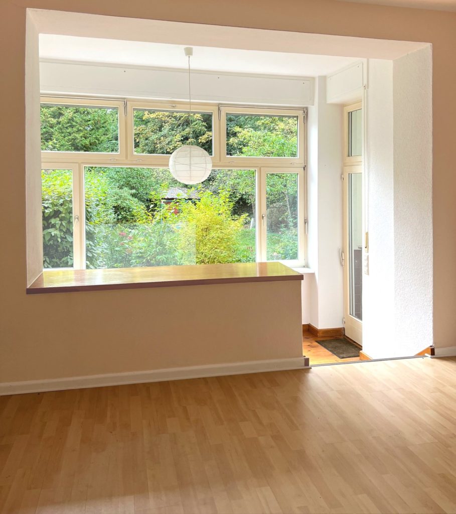 Blick aus der Gartenwohnung durch das große Panoramafenster ins Grüne